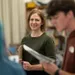 Female instructor smiles as she watches student read lines from script