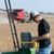 Student looks at seeds in the field
