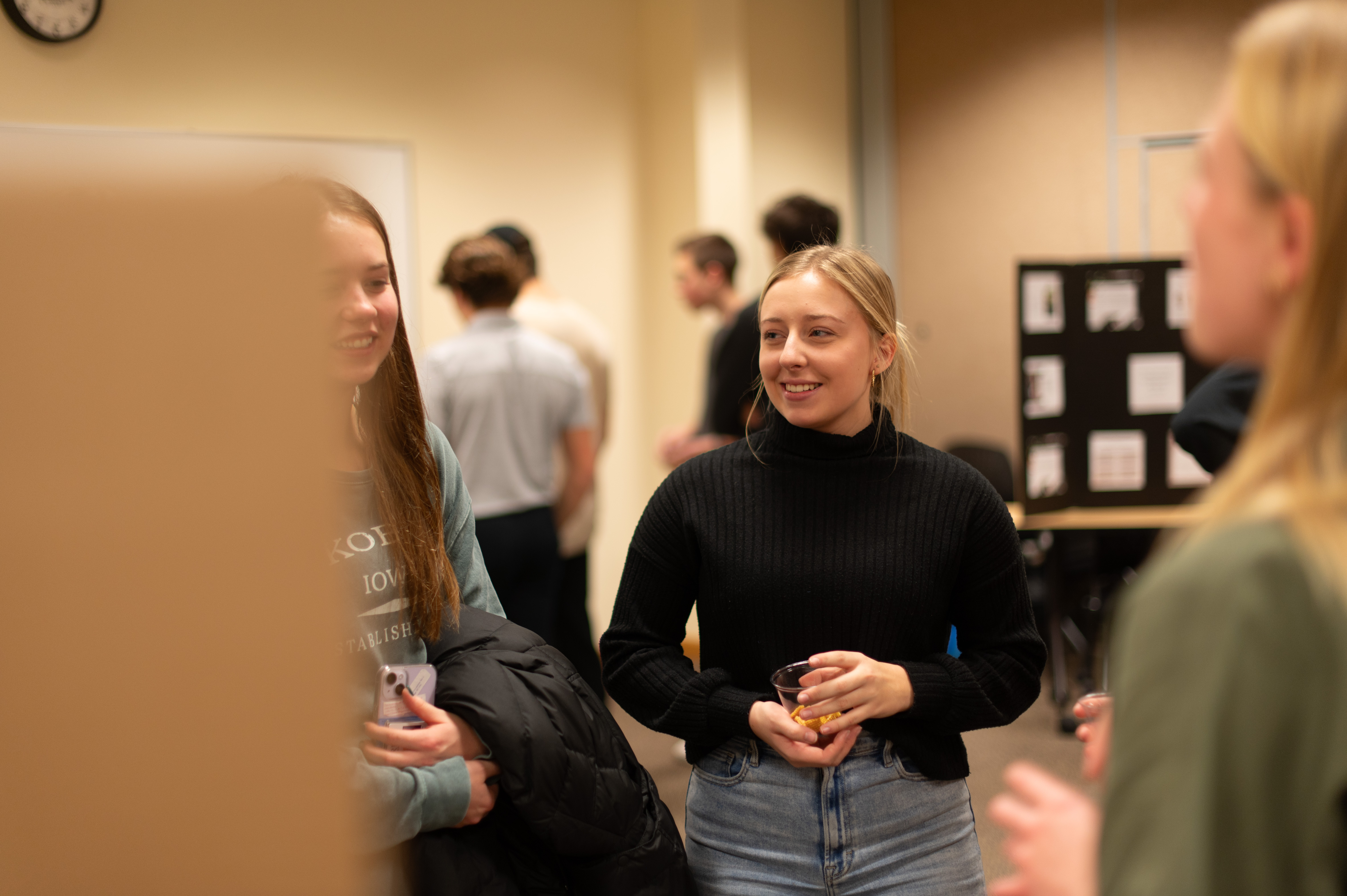 student listens to her classmates group presentation