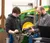Male student working on tractor parts with teacher's assistance