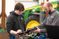 Male student working on tractor parts with teacher's assistance