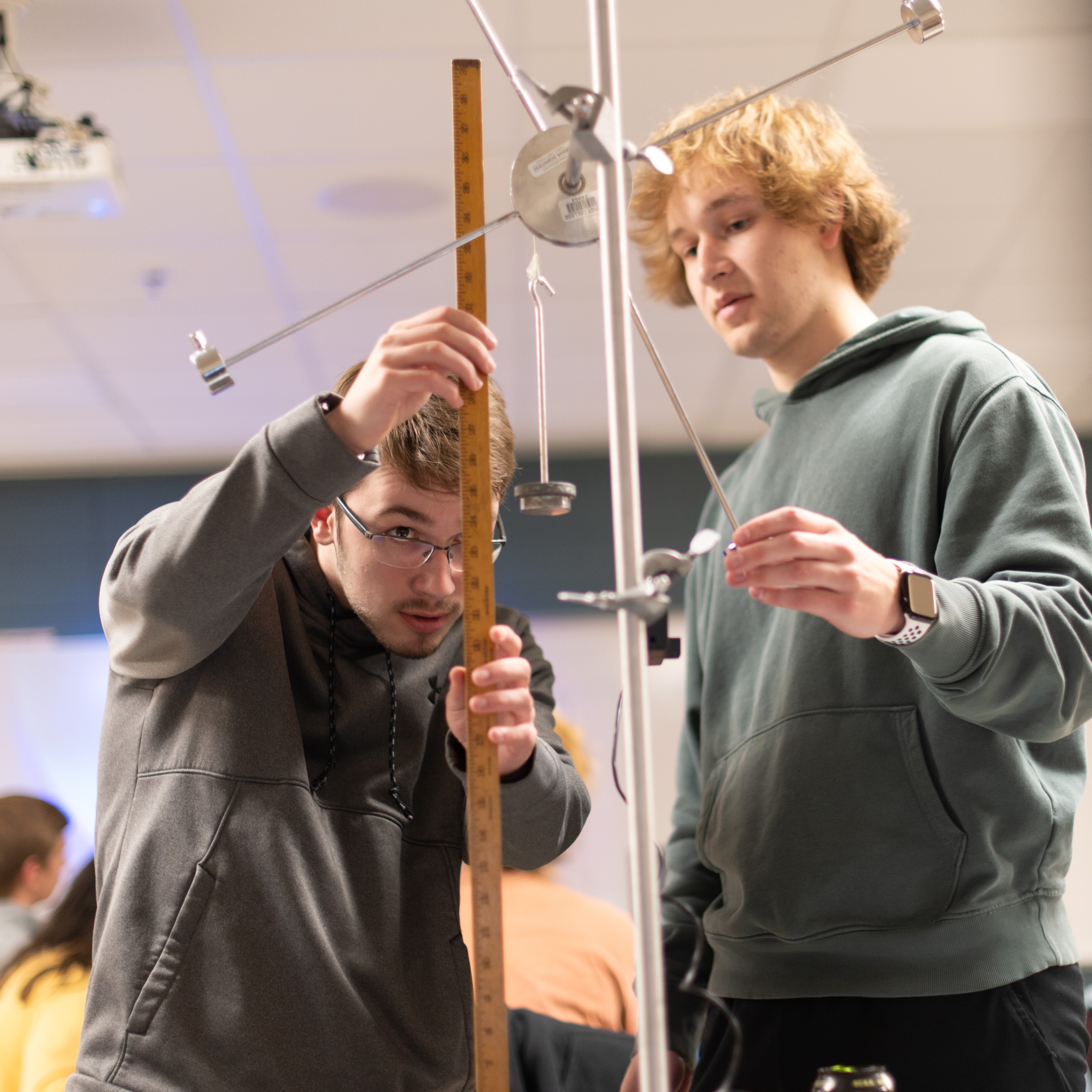 Male students using physics equipment