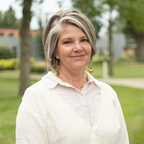 Smiling middle-aged woman with campus in background