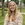 Young woman with long blond hair smiling outside