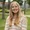 Young woman with long blond hair smiling outside