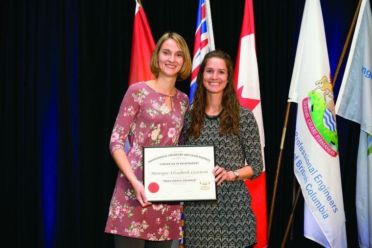 Two women hold up an award