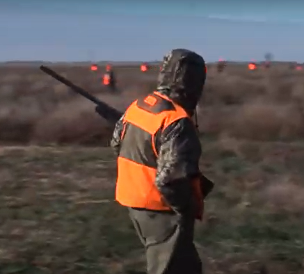 I picture of a hunter walking across a prairie