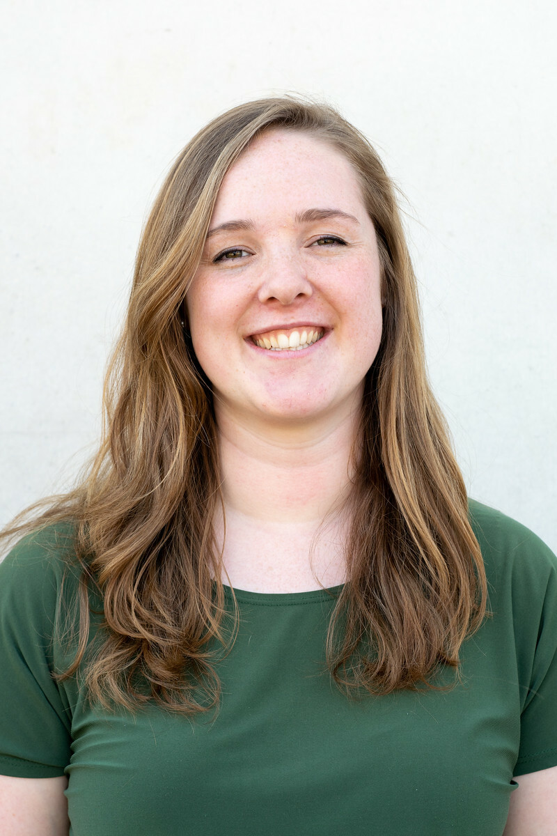A picture of a women with brown hair in a green shirt
