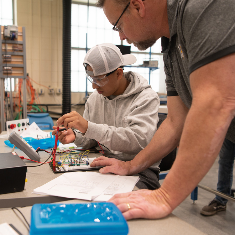 A Dordt Engineering Professor watching over a student doing an in-class activity