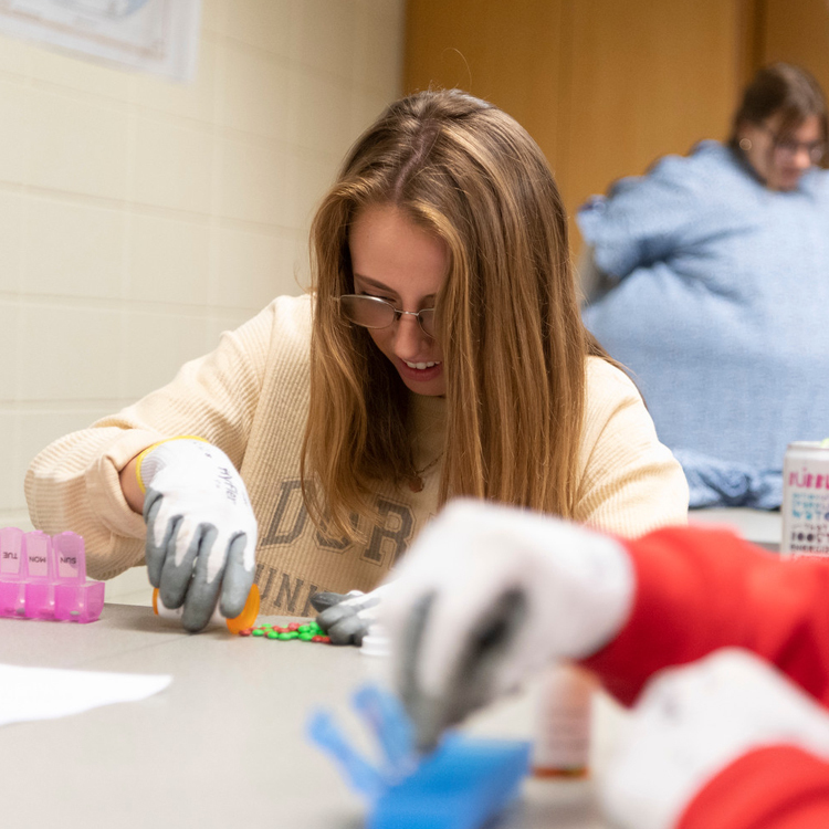 A Master of Social Work student putting pills into a bottle