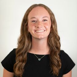 Smiling young lady with black shirt and parted long hair