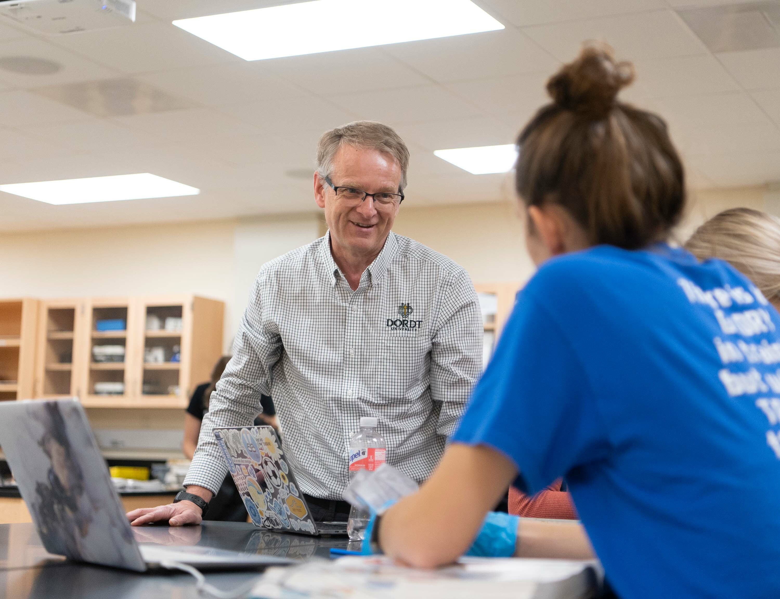 Dr. Jelsma interacts with a couple students during a lab