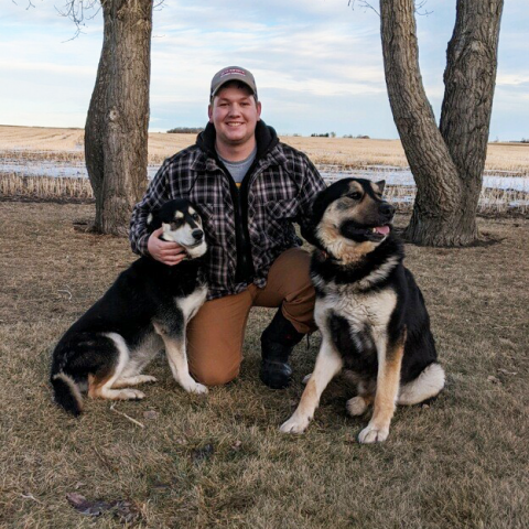 A picture of Braden Konyenbelt posing with his dogs