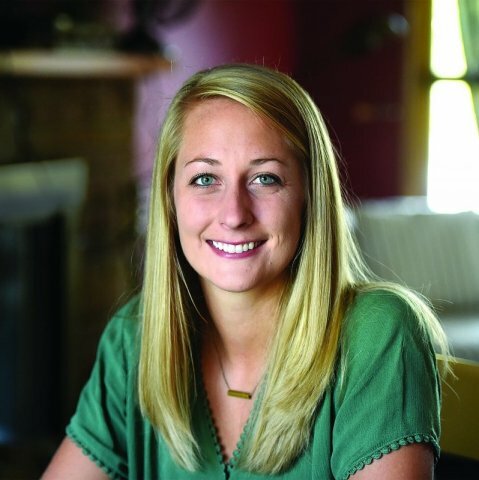 A picture of a women with blond hair wearing a green shirt