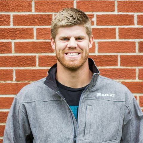 A picture of a man in a grey jacket with blond hair and a short beard