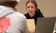 Female student looks up and discusses something with male student across from her in class