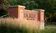 Brick and concrete sign of "Dordt University" is surrounded by prairie grass