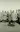 An old photo of a group of men in trench coats, with one digging a hole