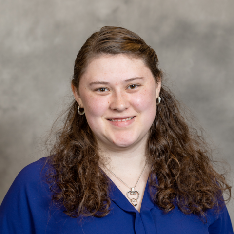 A picture of a women with brown hair wearing a blue shirt