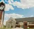A picture of Dordt's clocktower and campus center on a sunny day with big white clouds in the background.