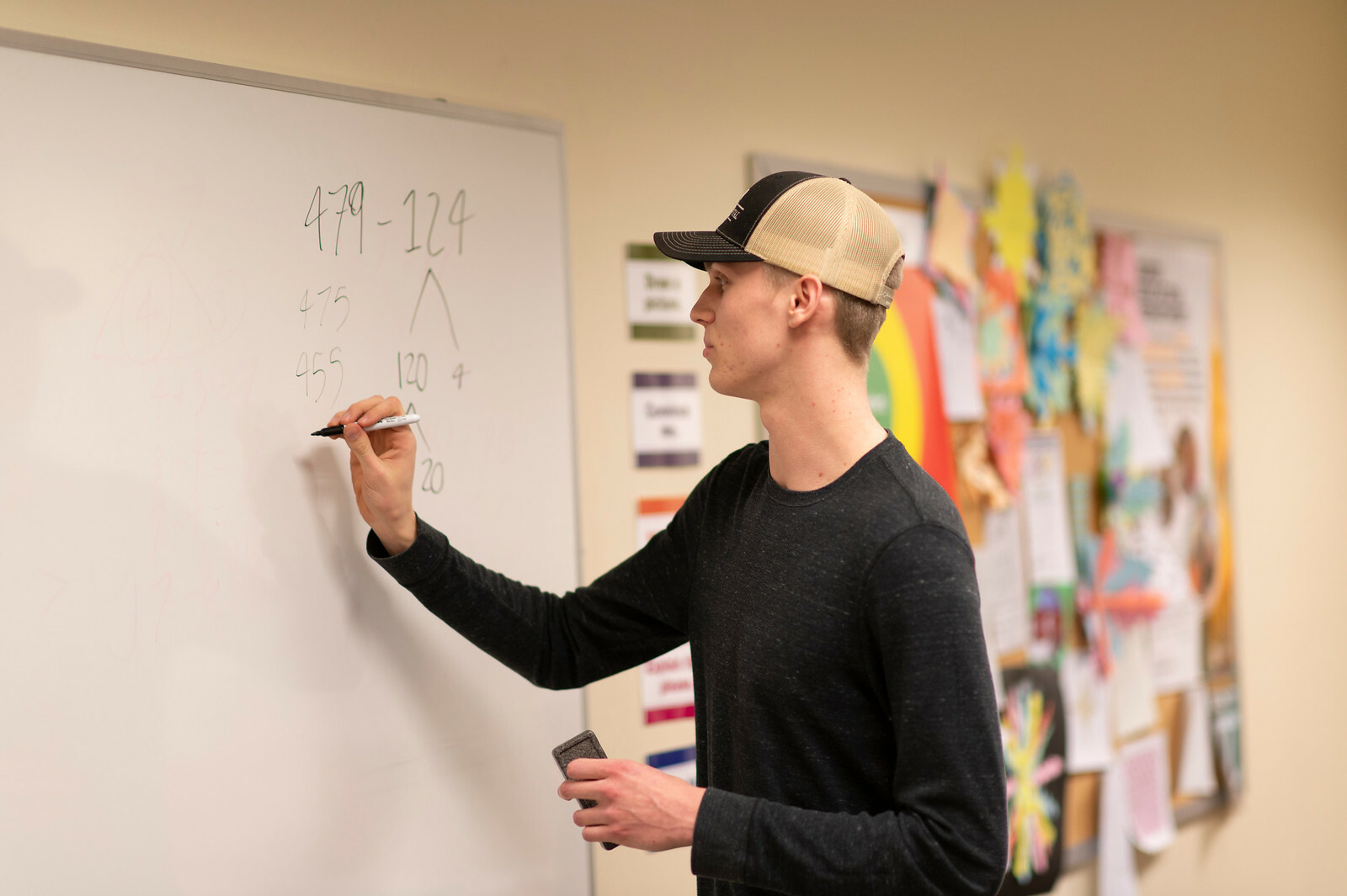 A student uses a whiteboard to work on a path problem