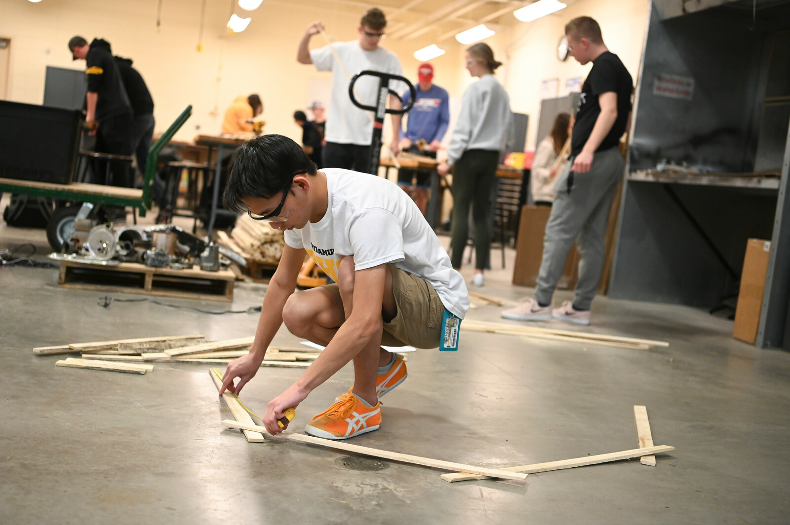 A picture of a student building a hexagon out of wood