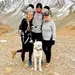 A picture of a international student with two members of his host family and a dog posing for a picture in the mountains