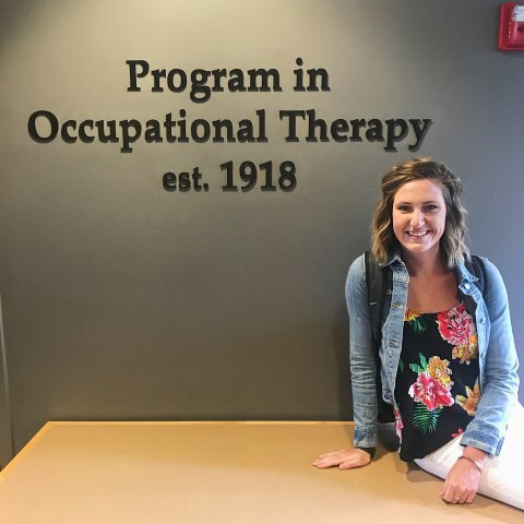 A picture of a women in a flower shirt sitting on a table