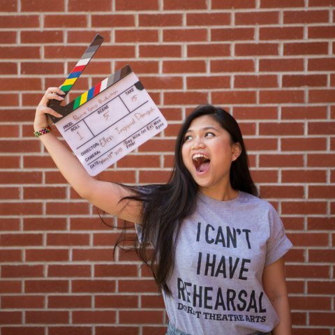 A picture of a women holding a clapperboard