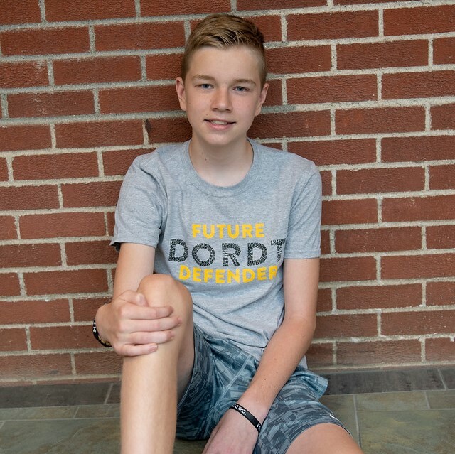 A child wearing a Future Dordt Defender shirt